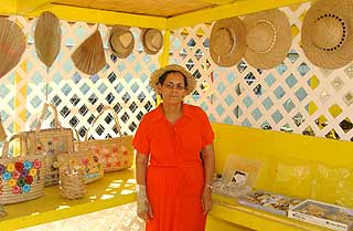 Ms Collen Gibson stands amidst her handiwork at Market Cayman on Saturday.